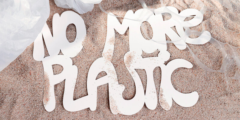 letters drawn in the sand to say no more plastic