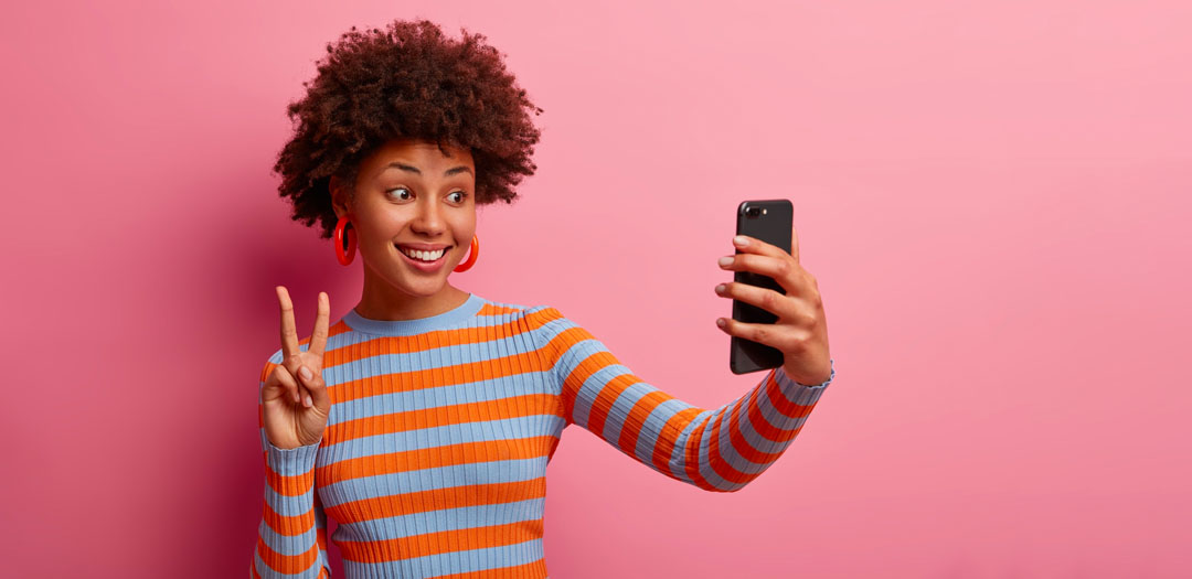 a happy woman filming a tiktok video with her mobile phone