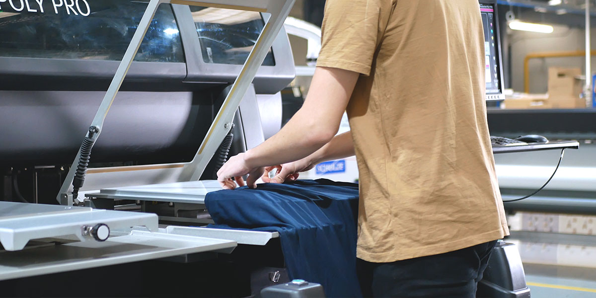 a print operator laying a t-shirt onto the print bed