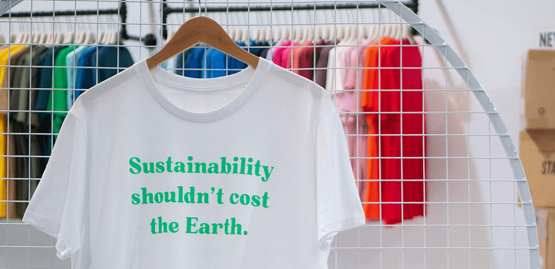 a white t-shirt with green printed text sustainability shouldn't cost the earth