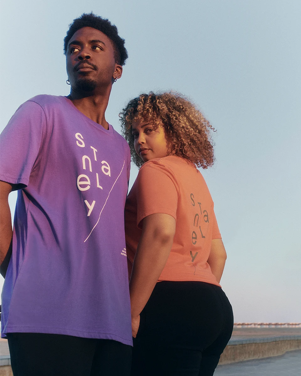 two models wearing colourful t-shirts on the beach